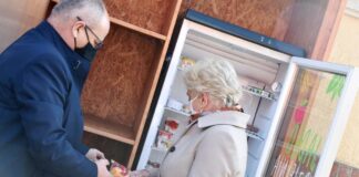 jadłodzielnia starosta Leszek Bizoń i członkini zarządu Krystyna Kuczera uzupełniają lodówkę społeczną w artykuły spożywcze